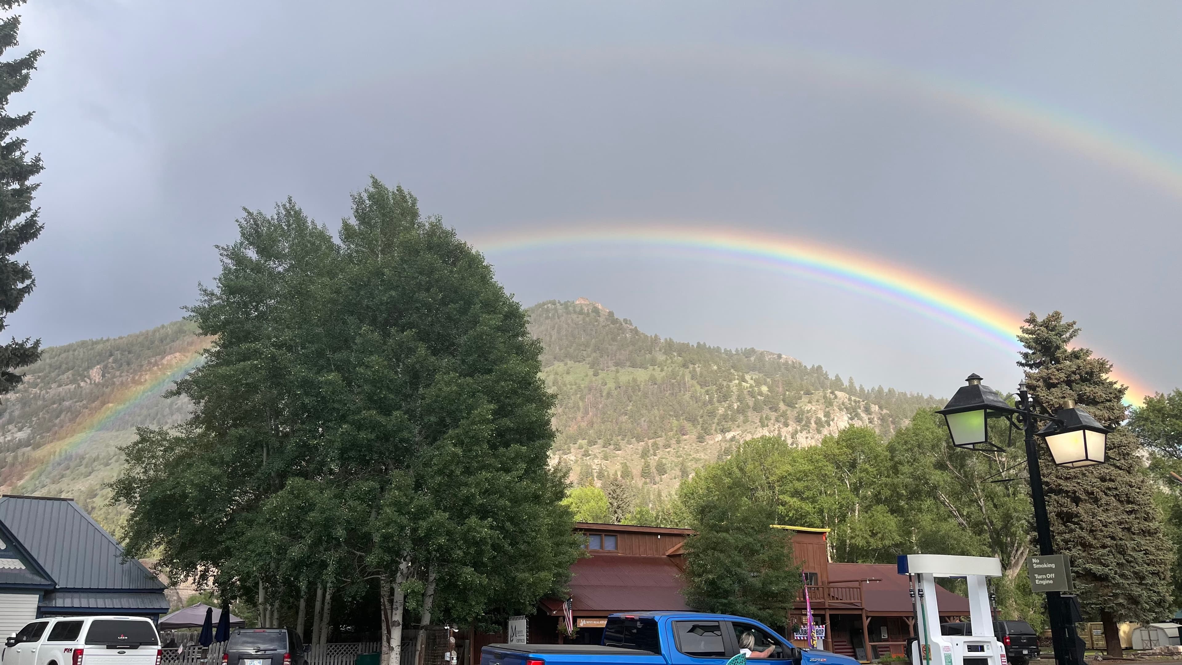 Full rainbow arching over mountain town
