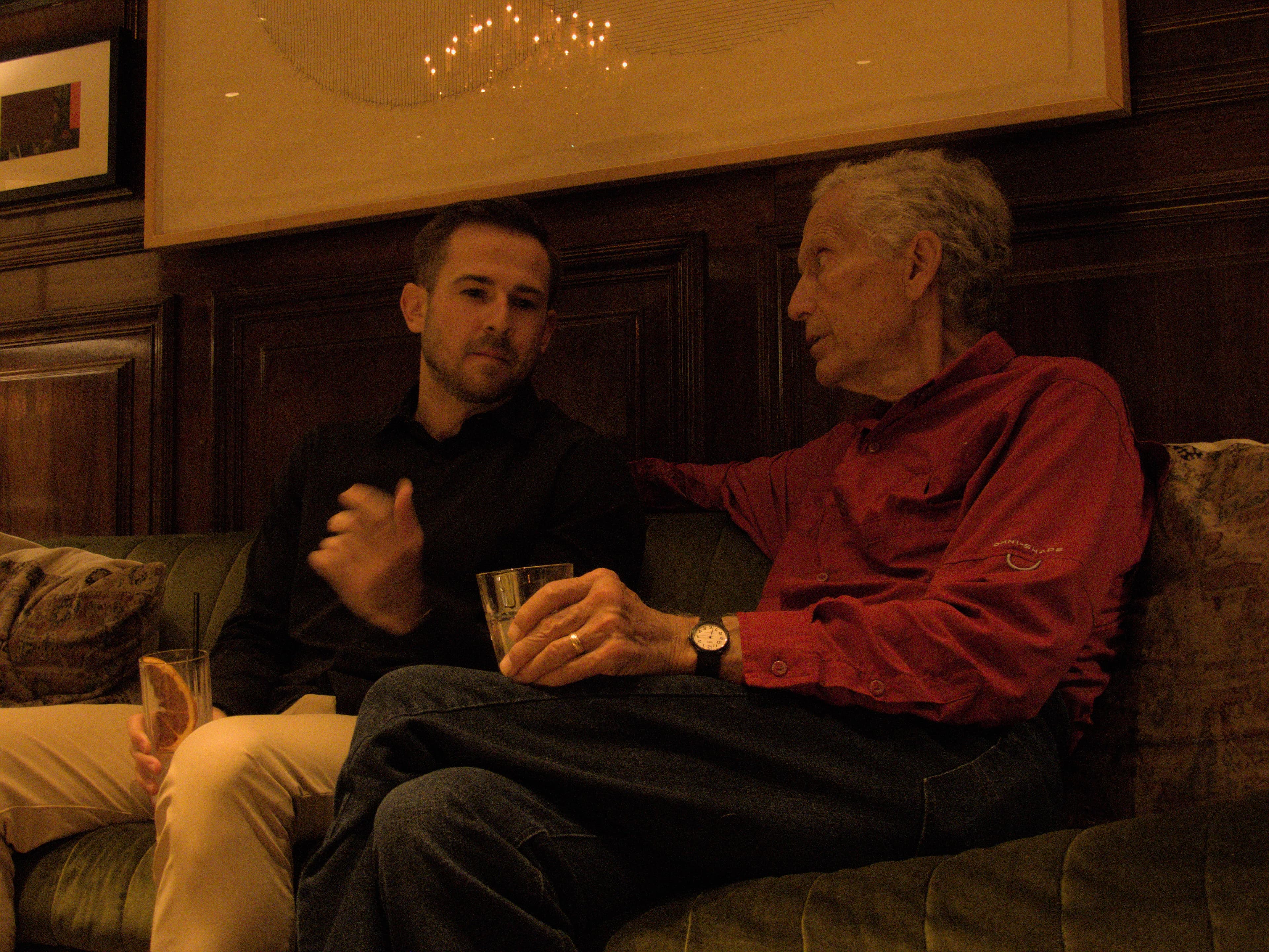 Two men in conversation at evening event
